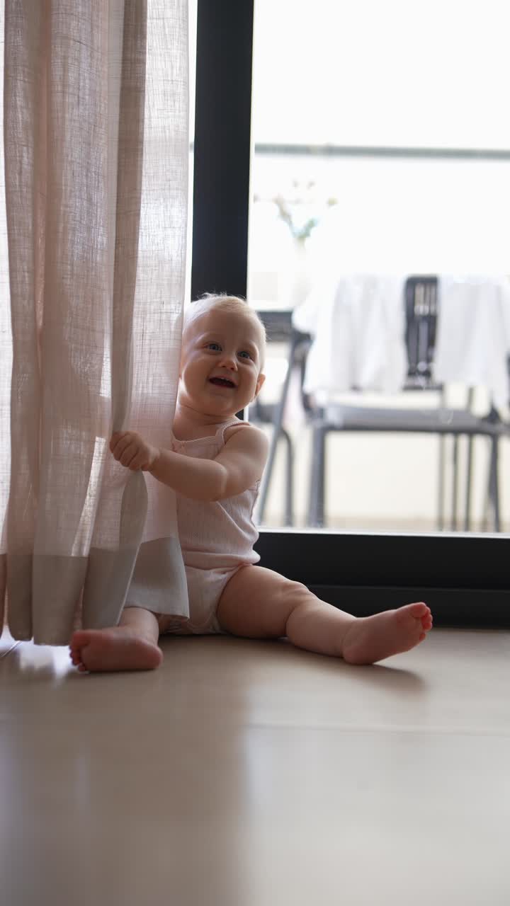 Bebé jugando con cortinas