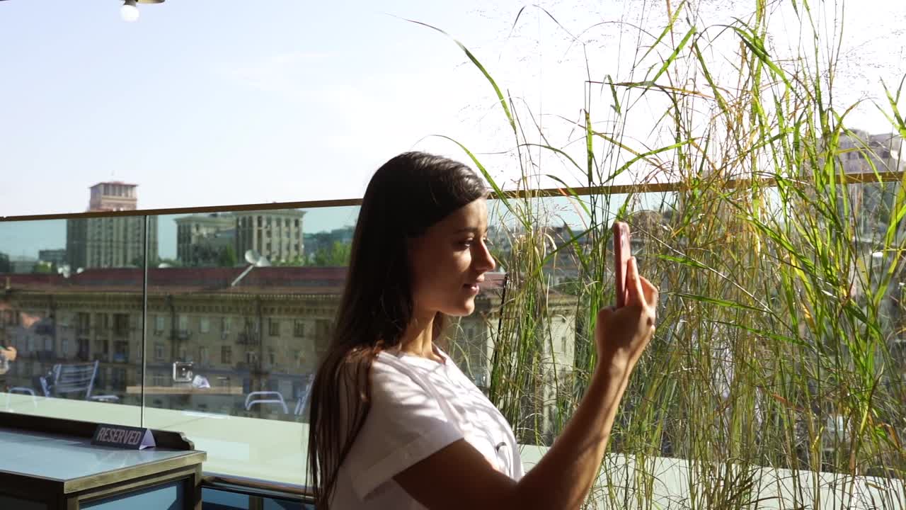 una mujer tomando una selfie en una terraza de un café en la azotea
