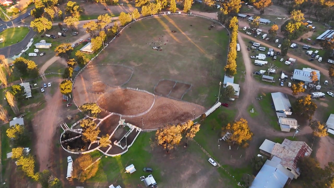 High-angle aerial shot overlooking a rural showground and equestrian arena in Coonabarabran, Australia.