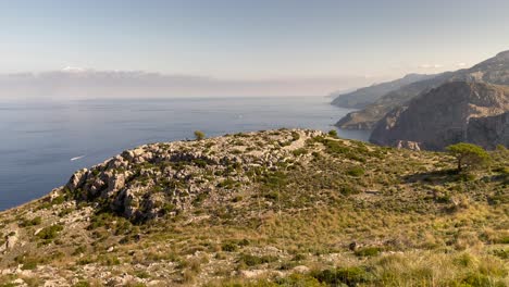 view over mountain range and sea at fondal de ses basses, mallorca, spain, tilt