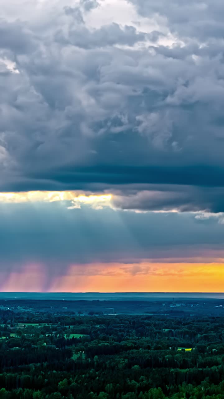 Vertical time-lapse showing fast-moving storm clouds over a rural landscape, with fading sunset light on the horizon as night approaches