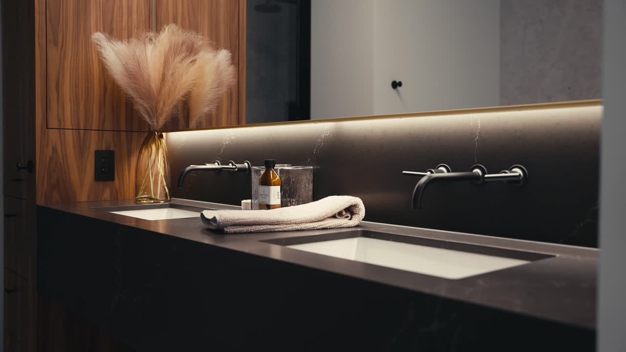 bancone nero del bagno, moderni rubinetti neri, con sapone e un asciugamano in un bagno moderno