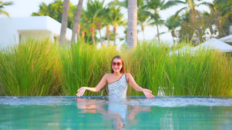 Una-Mujer-Bonita-Se-Divierte-Salpicando-El-Agua-En-La-Piscina-De-Un-Resort