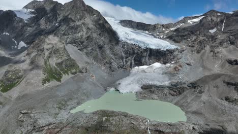 panorámica aérea a la izquierda hacia el amanecer toma de drone del lago oriental y el glaciar de fellaria - valmalenco - sondrio