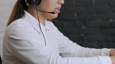 smiling woman call centre operator, customer support agent wears headset consults client online typing on laptop, talk in internet computer chat, helpline operator secretary make conference video call