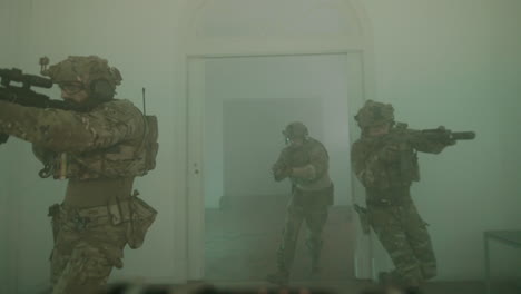 soldados armados con escopetas entrando en un edificio y jugando airsoft en interiores