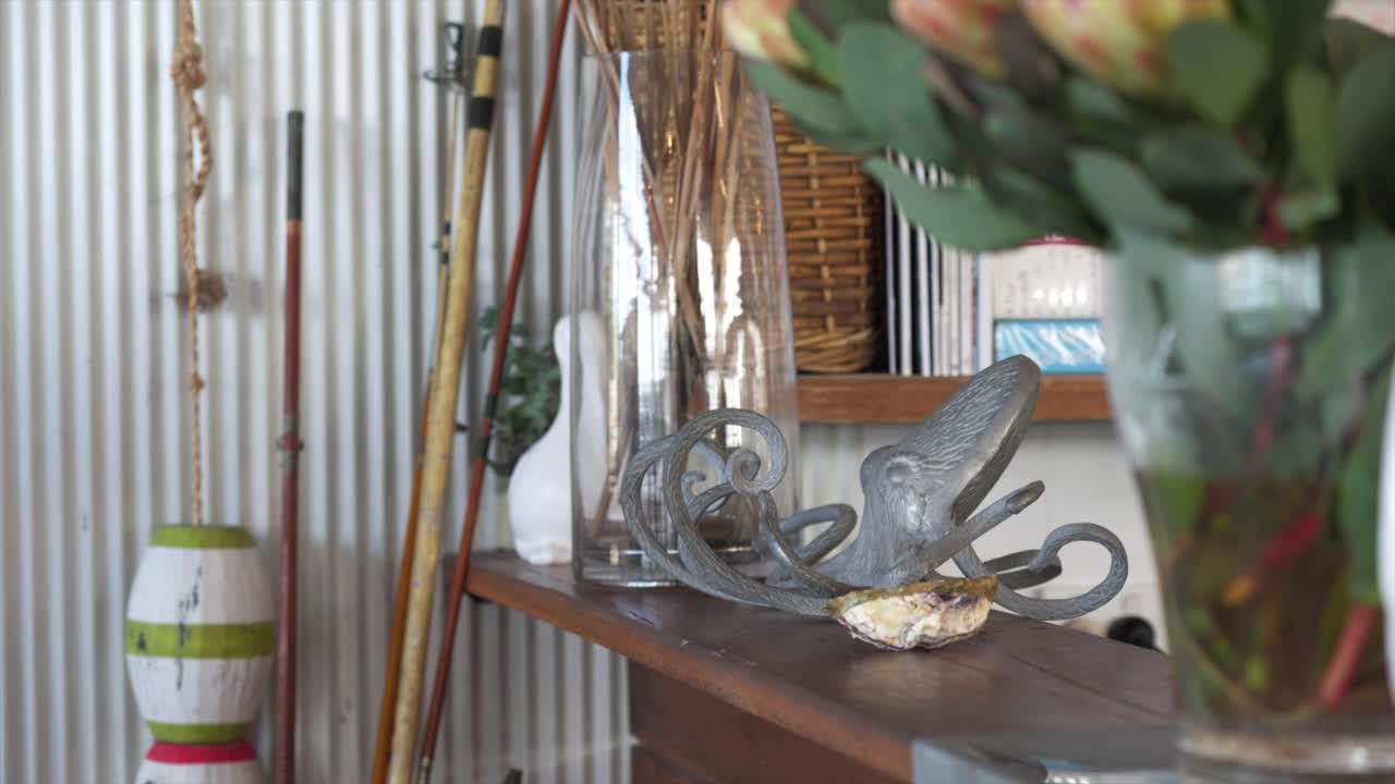 Nautical-themed interior decor with glass bottle, rope and marine objects on shelf