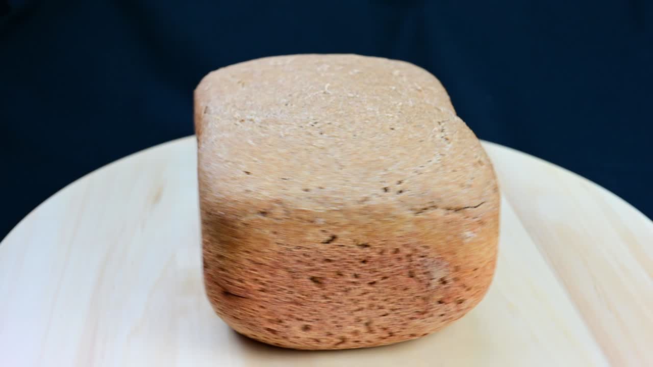 Freshly baked rye bread rotates on a wooden board