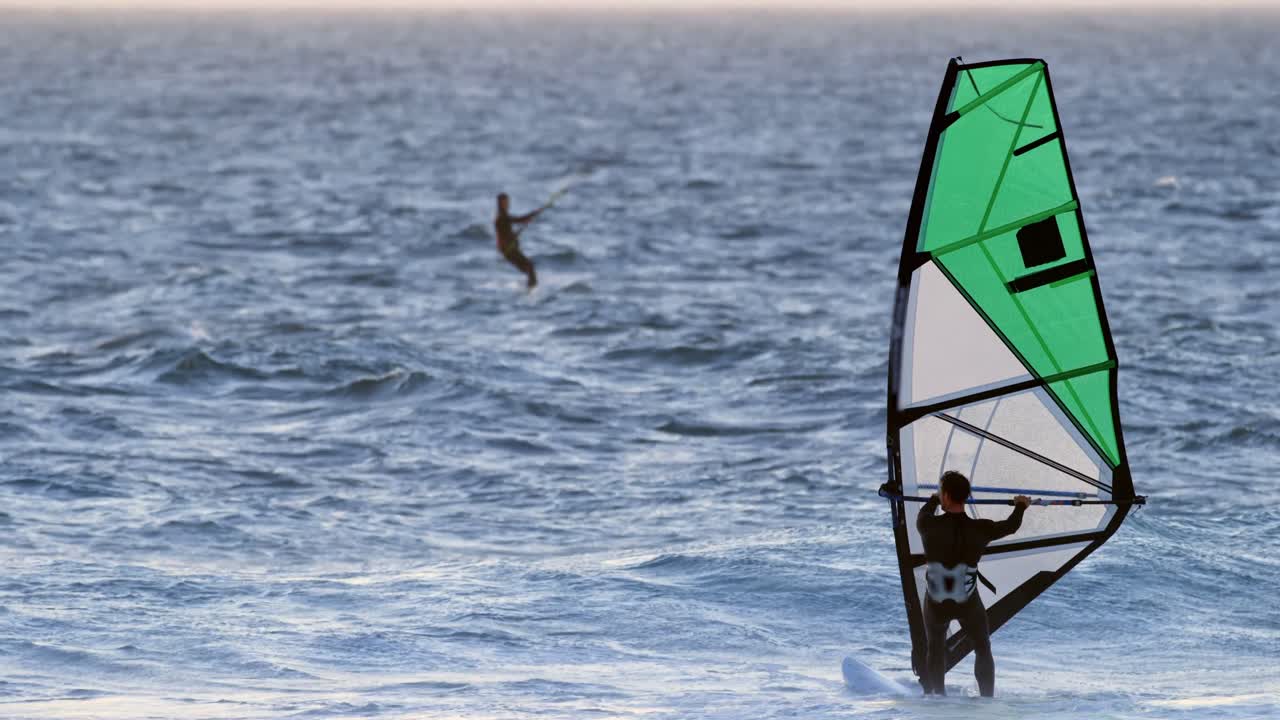 surfista masculino haciendo windsurf en la playa 4k