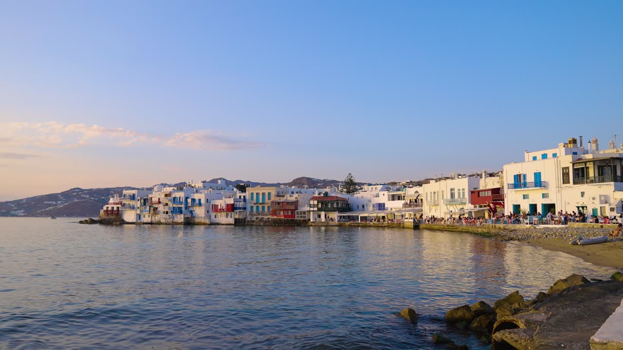 el tranquilo mar egeo frente a la orilla de la pequeña venecia al atardecer en mykonos, grecia