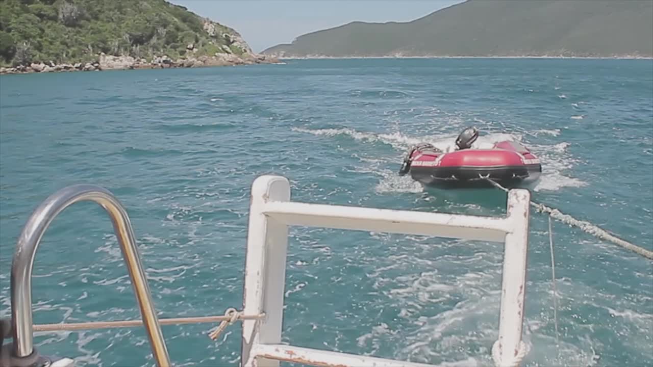 더 큰 보트에 밀리는 해변의 구조 보트