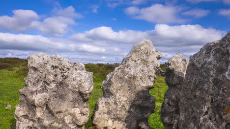 Timelapse-of-rural-nature-landscape-with-ruins-of-prehistoric-passage-tomb-stone-blocks-in-the-foreground-during-sunny-day-viewed-from-Carrowkeel-in-county-Sligo-in-Ireland