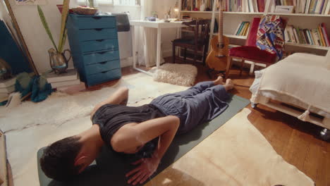 young man doing flow yoga practice at home
