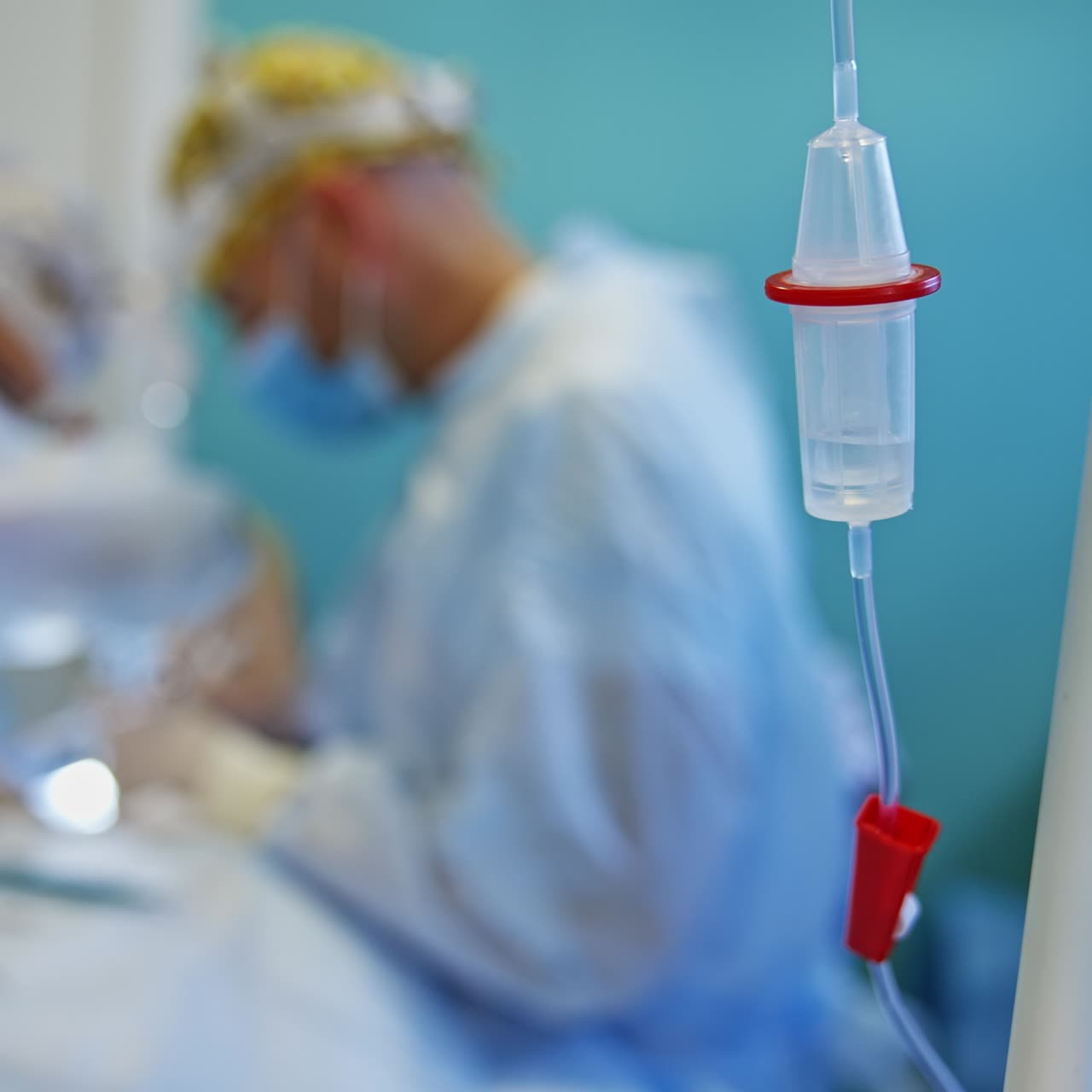 Drop counter with dripping medicines inside. Close up. Doctors work at surgical procedure at backdrop in blur