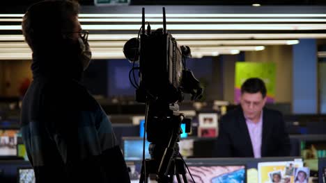 operador de televisión en el canal de producción de radiodifusión de televisión. operador de cámara en la sala de noticias disparar película de medios. camarógrafo trabajando en estudio de televisión producción de video entrevista de filmación. hacer programa de televisión o película.