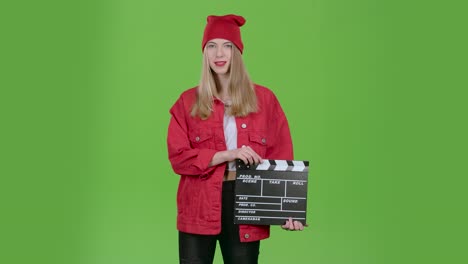 mujer con clapperboard en la pantalla verde