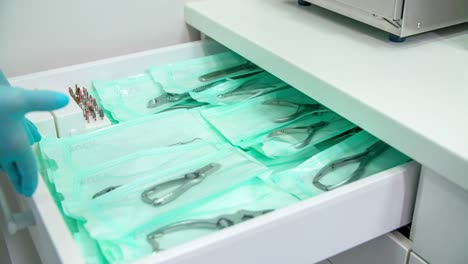 a hand with glove opening a drawer with equipment inside