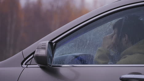 exterior shot of tired man driver suffering from headache after long drive