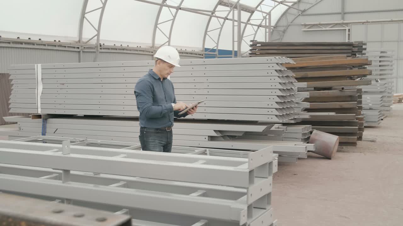 Construction Worker Inspecting Metal Beams in Warehouse