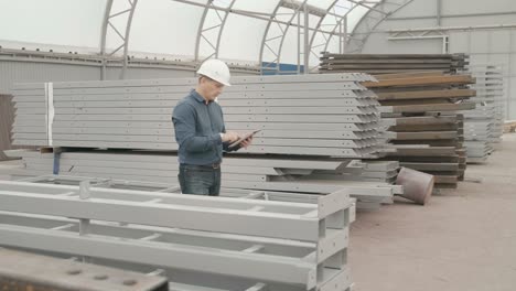 construction worker inspecting metal beams in warehouse