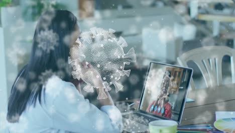 animation of covid 19 cells a over businesswoman on laptop video call