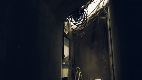dark industrial building interior with exposed wiring and concrete walls