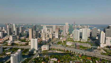 Aerial-descending-footage-of-modern-city.-High-rise-downtown-buildings-and-busy-multilane-highway-with-interchange.-Miami,-USA