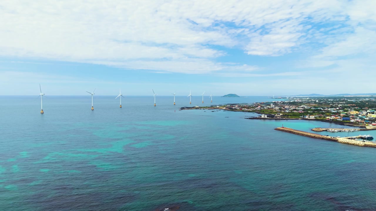 Luftfoto af havvindmøller langs turkis kystlinje nær Sinchang-ri landsby, Hangyeong-myeon, Jeju Island, Sydkorea