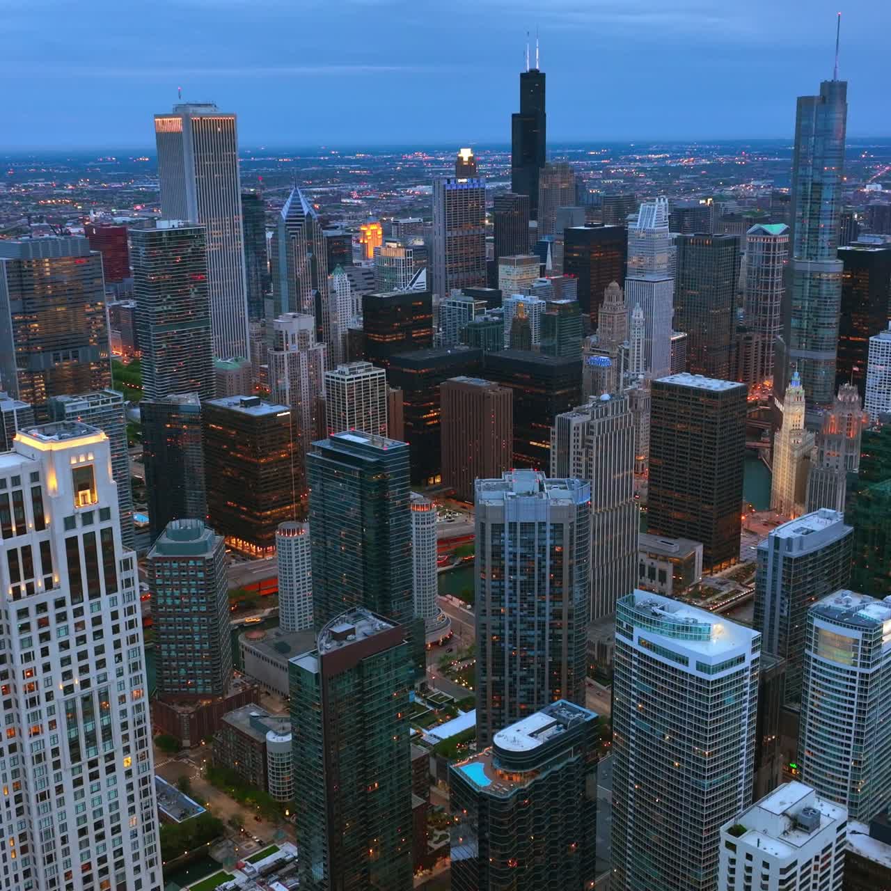 Lights appearing in the windows of metropolis architecture. Beautiful skyscrapers of Chicago downtown from aerial perspective