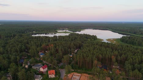 aerial sunset view over dzirnezers lake in carnikava, latvia gauja village, siguļi, krievu island and distant baltic sea horizon in scenic natural landscape captured by drone