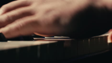 close up of keyboard player hands playing rock music with keyboard at the concert in studio, rehearsal room, macro play on synthesizer.