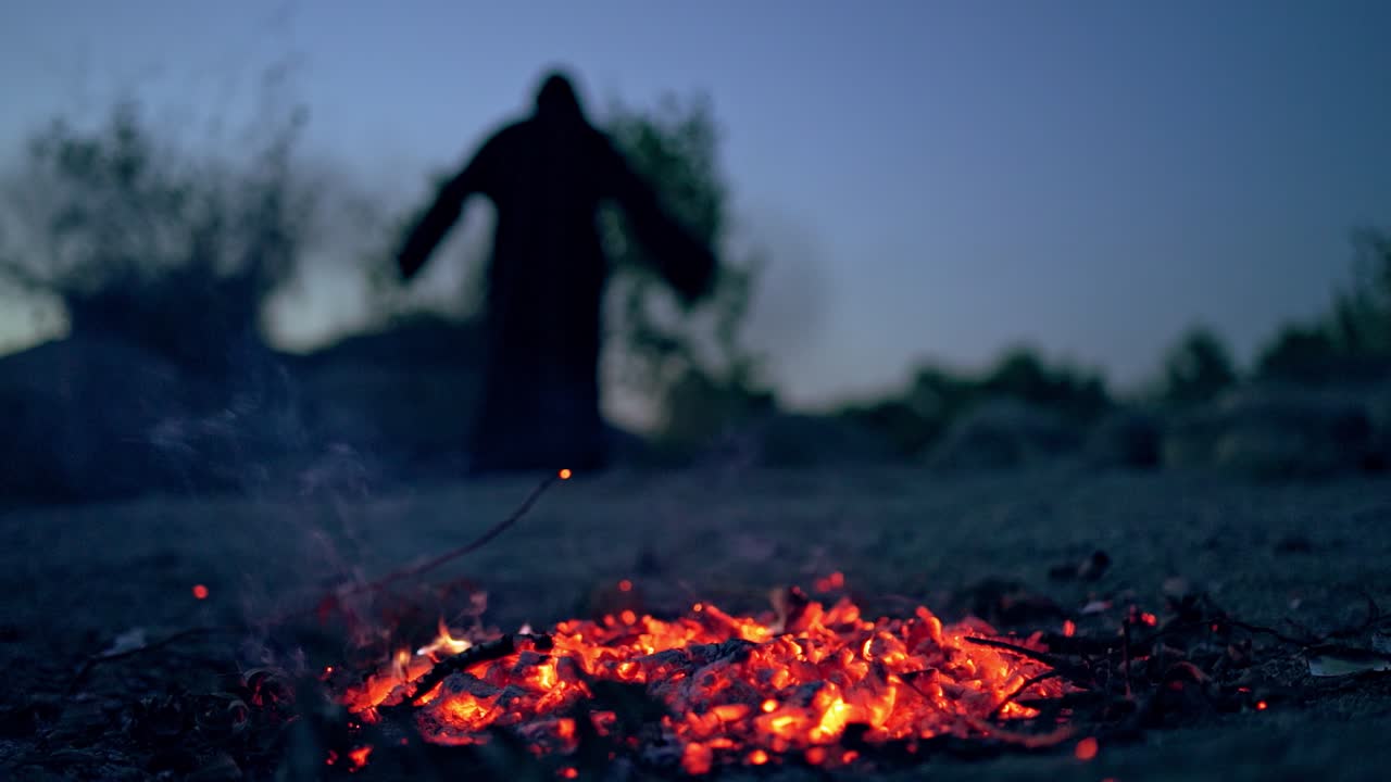 Glowing coals after flame on blurred background with death. Horrible atmosphere of ghost in black at night. Halloween.