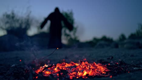 glowing coals after flame on blurred background with death. horrible atmosphere of ghost in black at night. halloween.