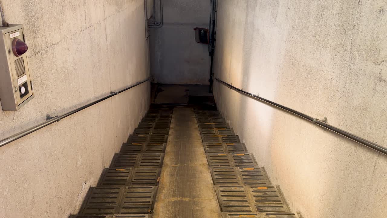 Narrow Concrete Staircase Leading Down into a Dark Underground Passage