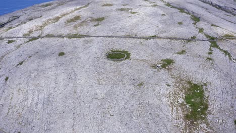 Flyover-barren-rock-landscape-of-the-Burren,-ancient-ringfort-ruins