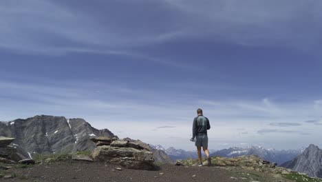 Hiker-walking-on-top-of-ridge-taking-photos-circling-Rockies-Kananaskis-Alberta-Canada