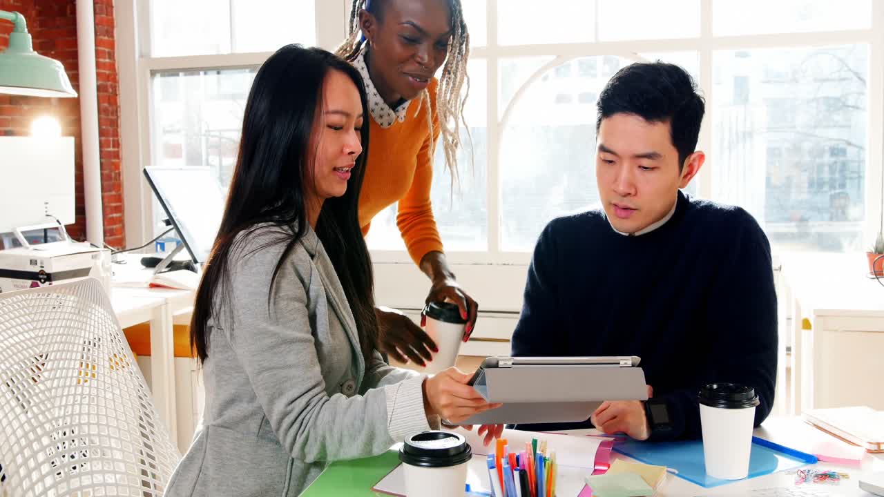 비즈니스 임원 들 이 디지털 태블릿 을 통해 토론 하고 있다