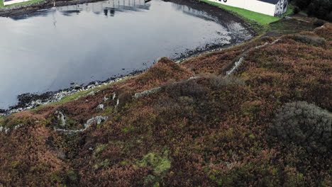 Luftaufnahme-Der-Whiskybrennerei-Laphroaig-Mit-Blick-Auf-Die-Brennerei-Und-Die-Bucht