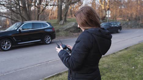 mujer piloto volando un dron al comienzo de la temporada de primavera en suecia, cerca de la puesta del sol