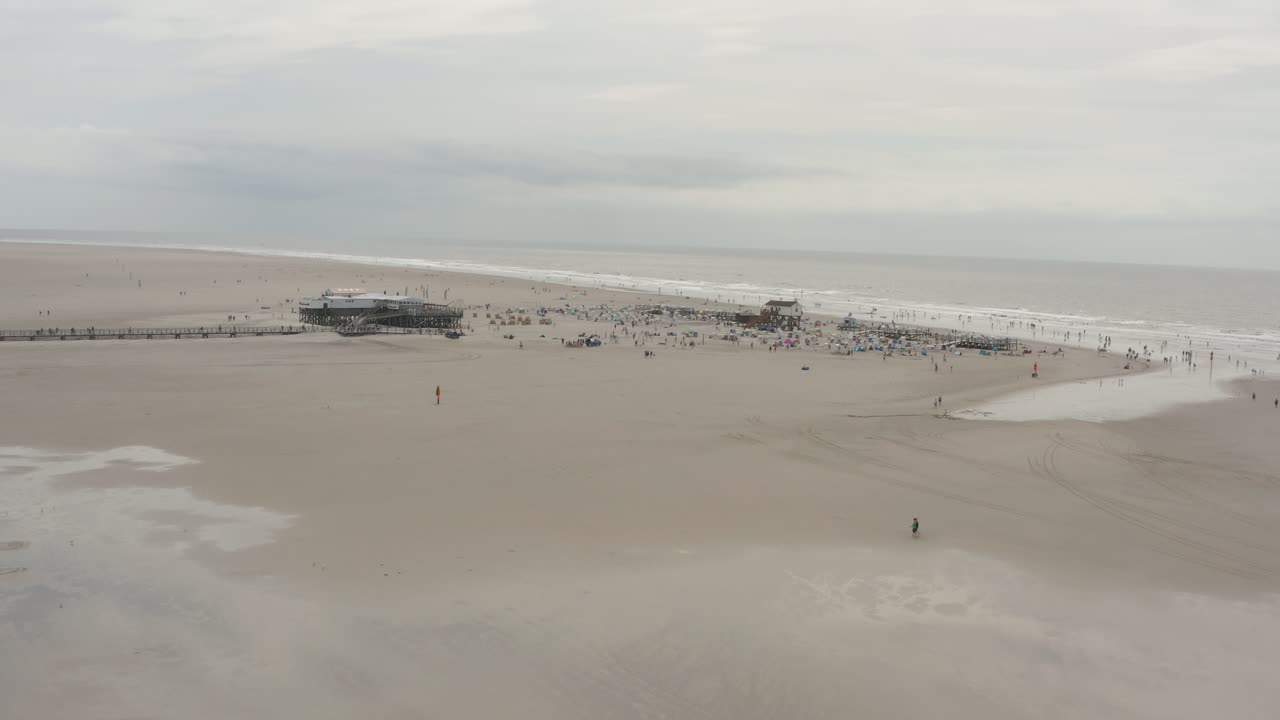 Drone - Aerial panorama shot of the sandy beach with tourists and people in St. Peter Ording at the north sea, schleswig holstein, germany, 30p