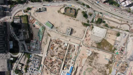 Mega-Construction-project-of-a-Housing-and-business-district-at-Kai-Tak-downtown-Hong-Kong,-with-vast-infrastructure-development-land-and-an-underwater-tunnel-laying-operation,-Aerial-view