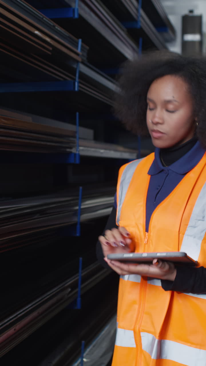 Warehouse female worker in a metalworking factory taking inventory counts physical stock checking