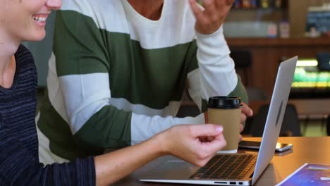 ejecutivo discutiendo sobre la computadora portátil en la cafetería de la oficina 4k
