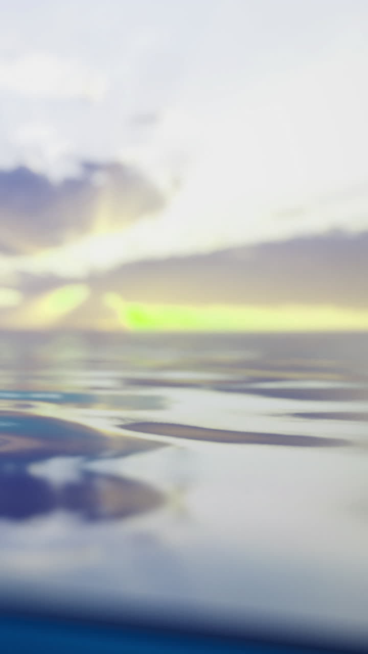 Sunset over calm ocean waters with clouds in the sky