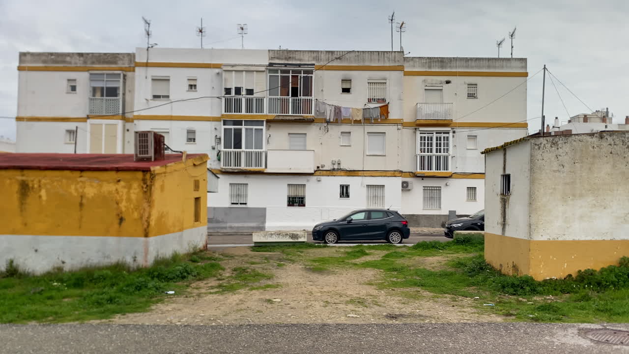 Beboelsesejendom, der viser dagligliv og urban arkitektur i en spansk by under en overskyet himmel.