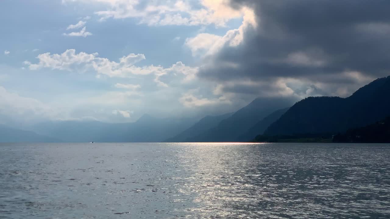 Serene Lake Landscape with Mountain Range and Dramatic Sky