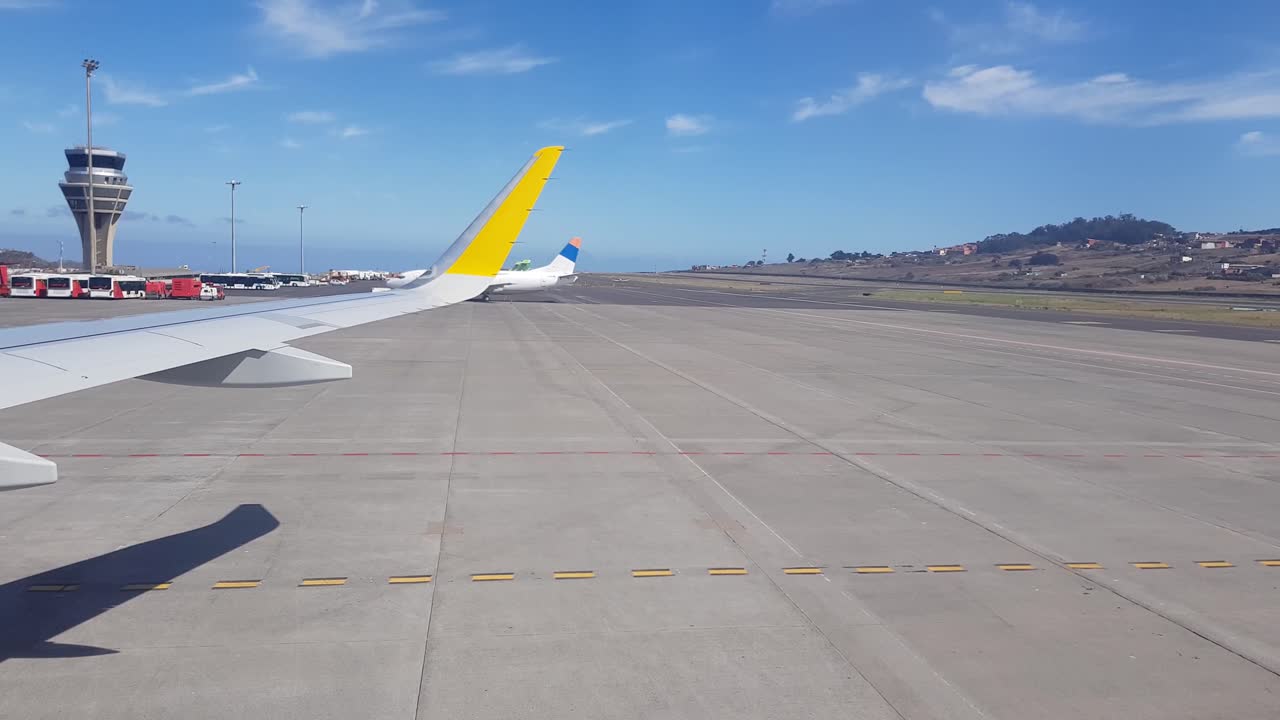 Sebuah pesawat bergerak mundur di landasan pacu bandara Spanyol - Bidikan lebar.