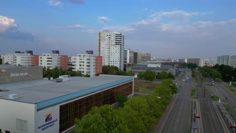 aerial view of a city with high-rise buildings and a sports hall