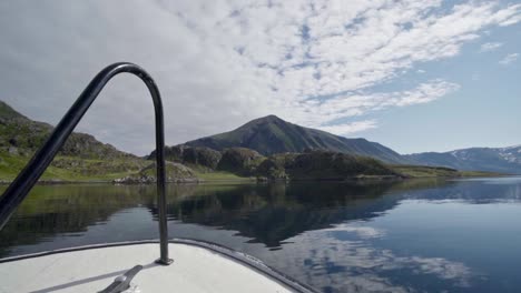 cruising ship towards lush mountains on pristine river during sunny day in norway