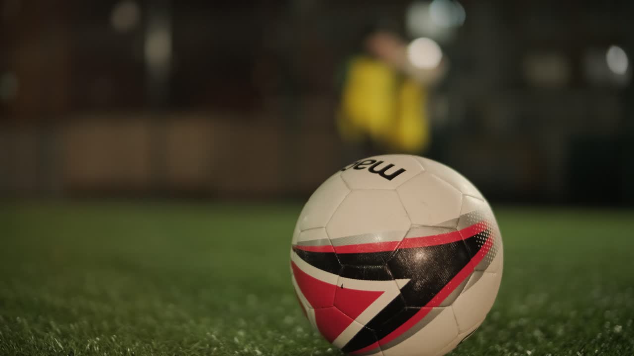 Et børnefodboldhold træner på stadion under vejledning af en træner. Børn i sportstøj øver boldøvelser, forbedrer teknik og udvikler teamwork på den grønne bane
